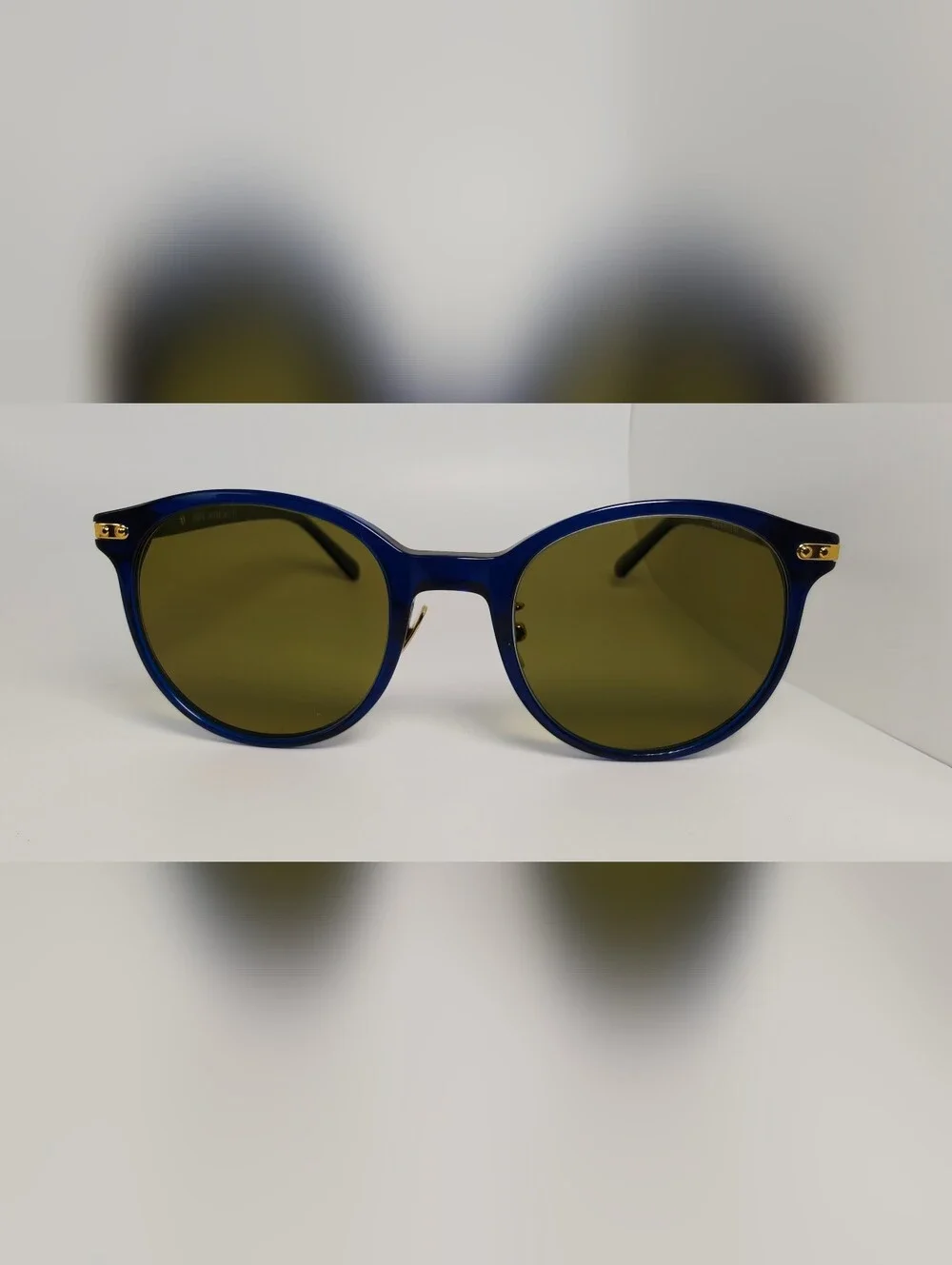 Dotti. Round Navy Translucent frame. Gold Hinge Extends to frame front.